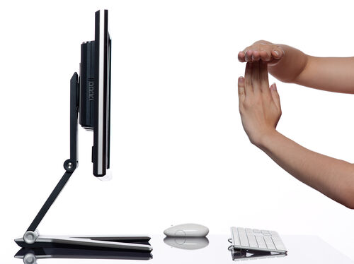 A pair of hands in front of a computer screen